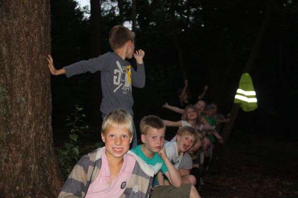 De jongere kinderen spelen een eigen spel in het donkere bos